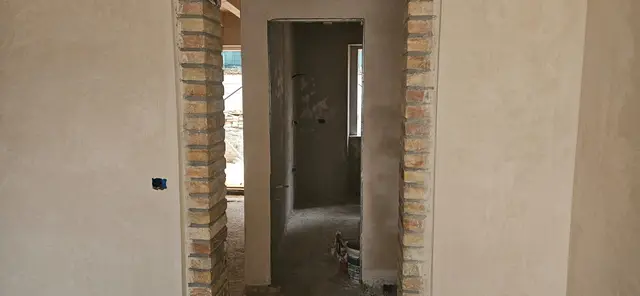Pereți tencuiți și gletuiți într-o casă în renovare